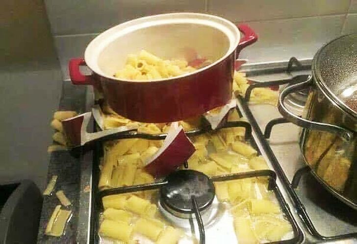 broken ceramic cooking pot spilling pasta onto stove