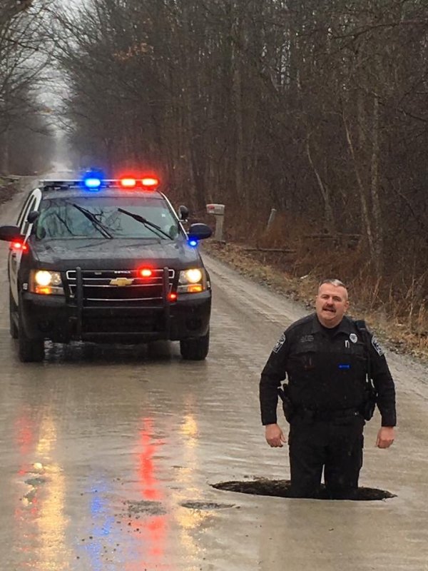 police officer standing in pothole