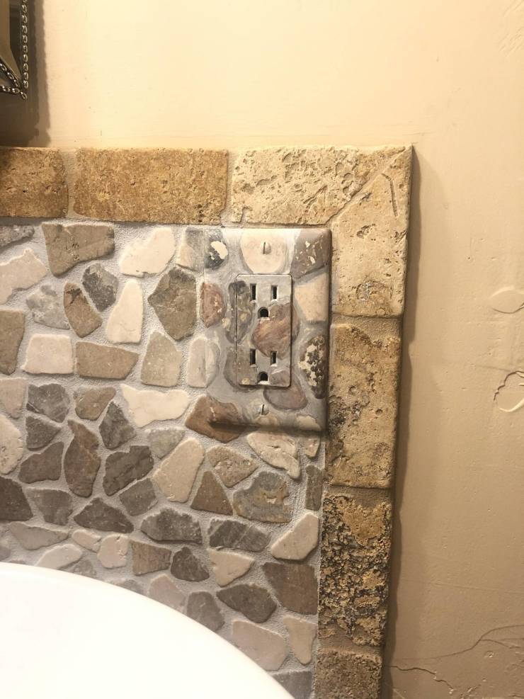 wall socket painted to blend in with rocks