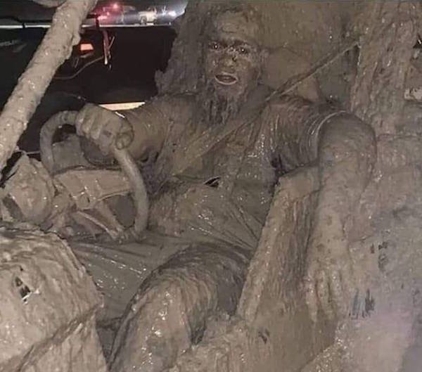 guy covered in mud sitting in his truck