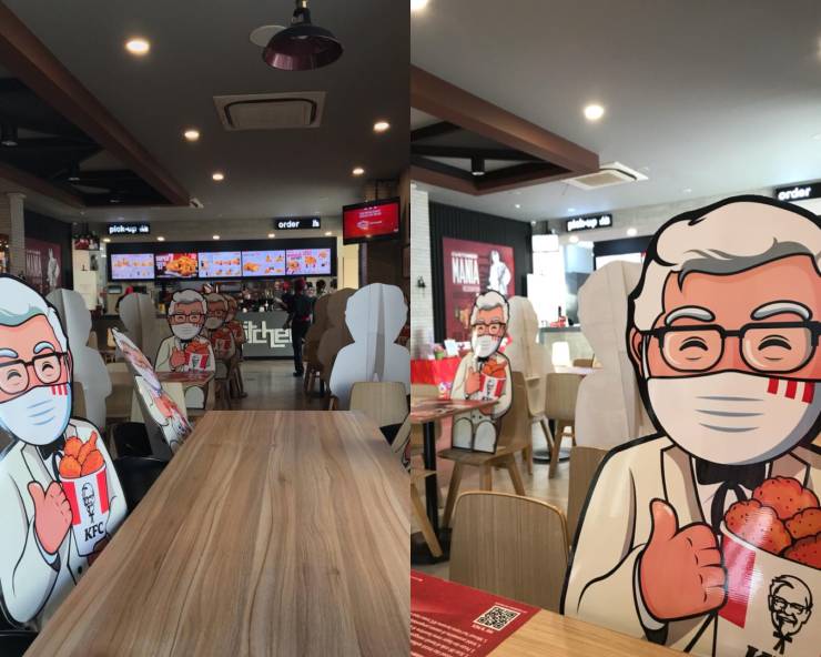 “This KFC restaurant uses Colonel Sanders cutouts to enforce physical distancing seating.”