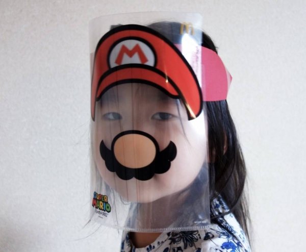 little girl wearing mario face shield