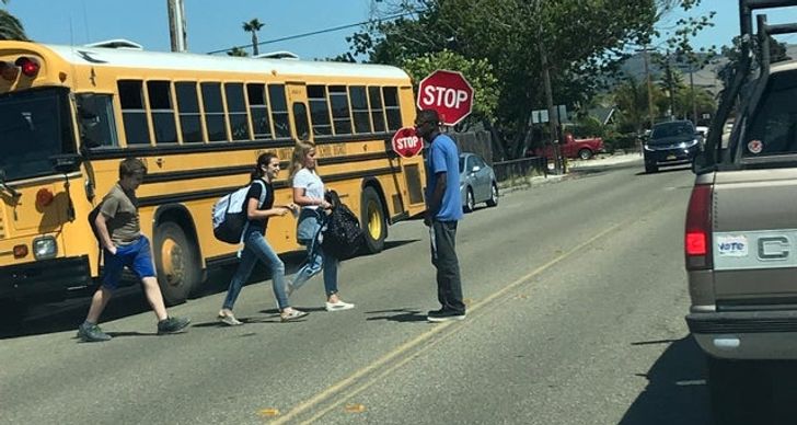 bus driver making sure kids cross the street safely