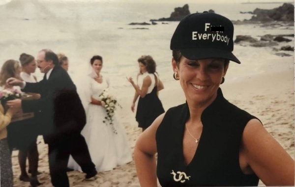 woman at wedding wearing a hat that says Fuck Everybody