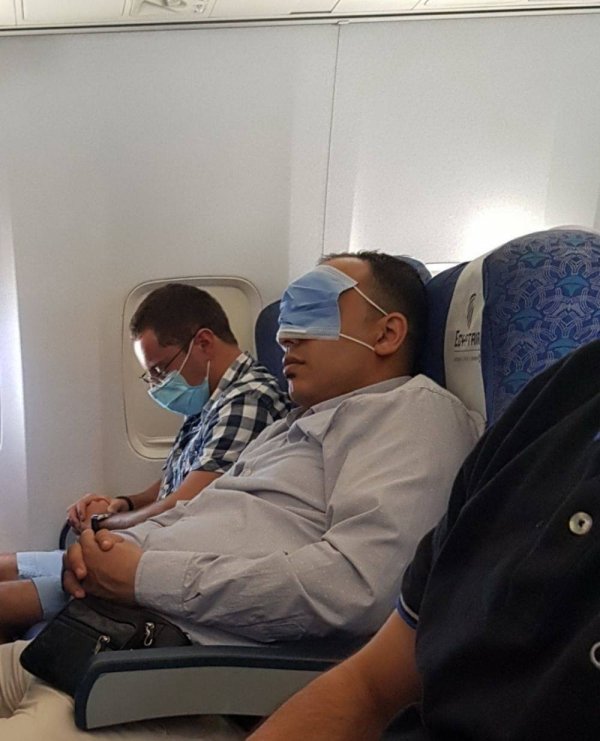 guy sleeping on plane wearing face mask over his eyes