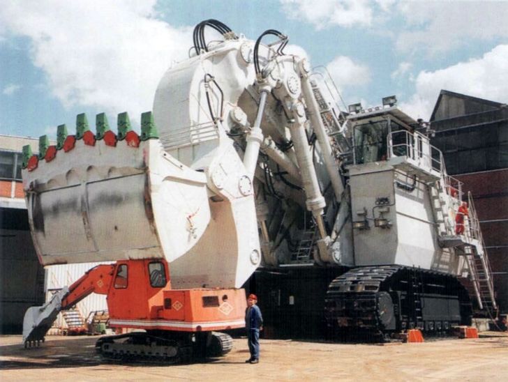 The normal-sized excavator can be easily placed inside the bucket of this large one.