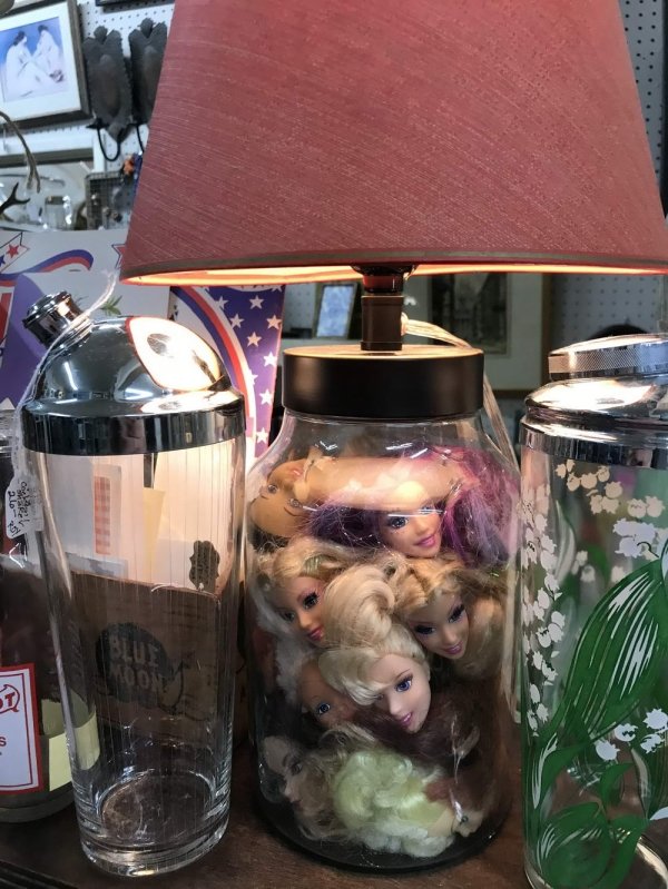 lamp base is a jar filled with doll heads