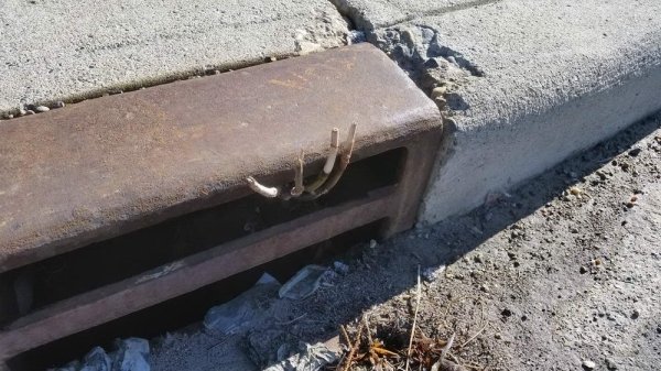 creepy hand coming out of sewer opening