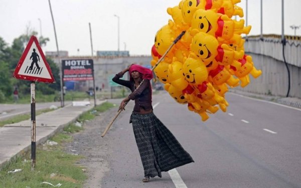 woman holding winnie the pooh ballons