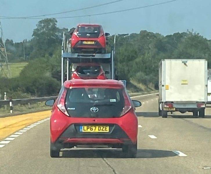"Car transporter full of red Toyota Aygos being followed by a Toyota Aygo that was nothing to do with the transportation. The lone Aygos later turned off the motorway and we felt sad for it having to wave goodbye to its friends."