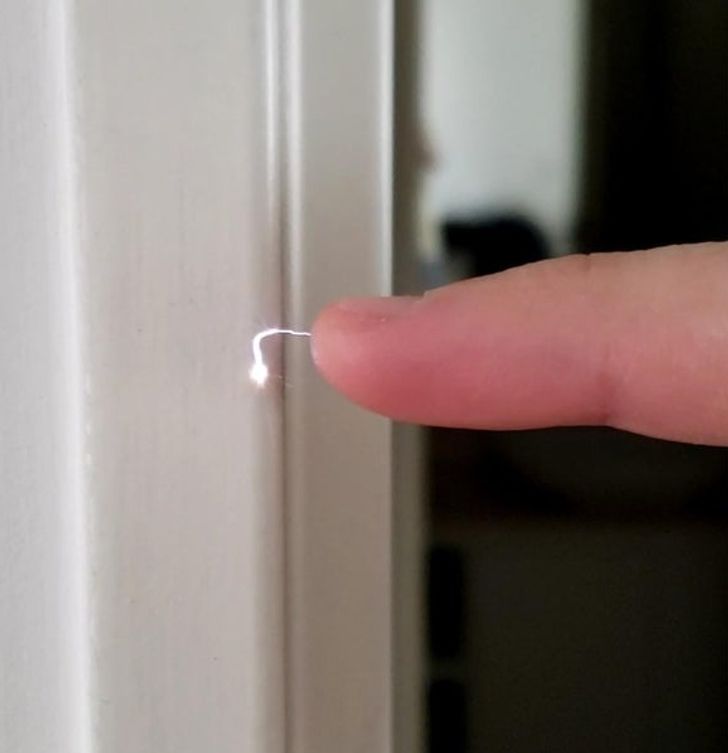 His finger can discharge static electricity against a door frame.