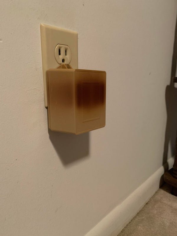 I moved into an old house and found this screwed to the power outlet. It’s warm to the touch, and has apparently been here for years. What is this?

A: It’s a transformer. Probably for a burglar alarm, but could be for a sprinkler controller or other low voltage system.