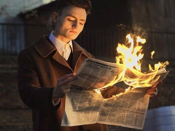 reading burning newspaper