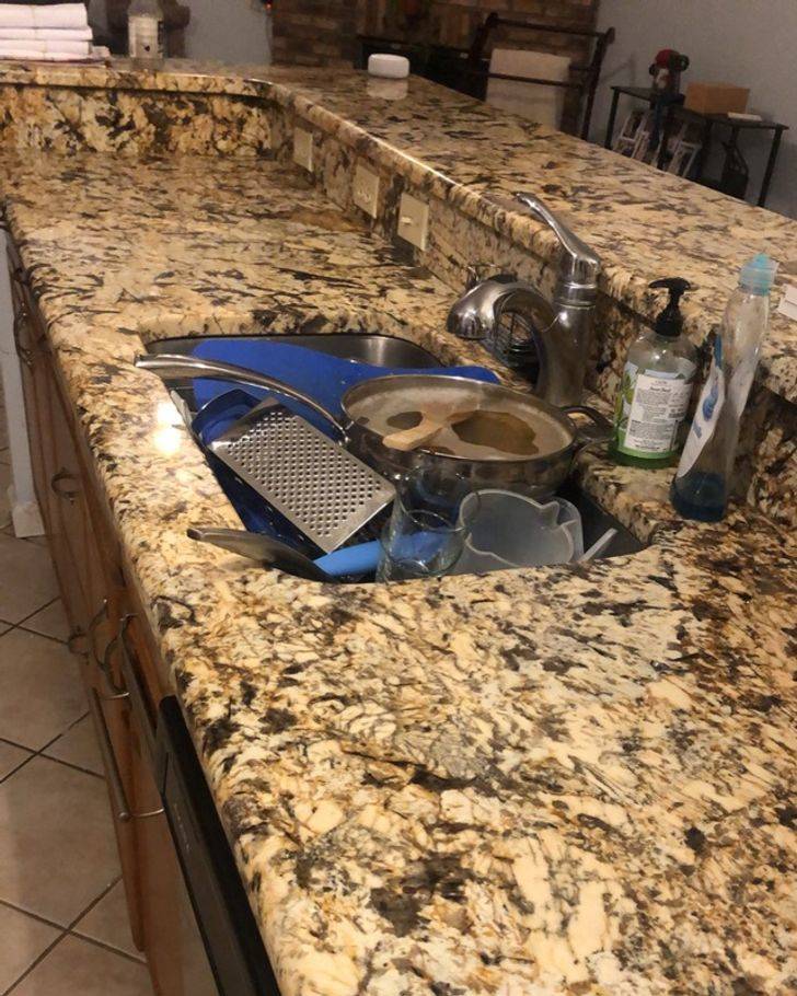 countertop with dishes in the sink