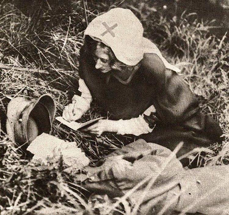 A Red Cross nurse writing the last words of a dying British soldier in 1917