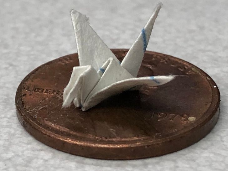 “An uber small paper crane I made — the penny is for scale.”