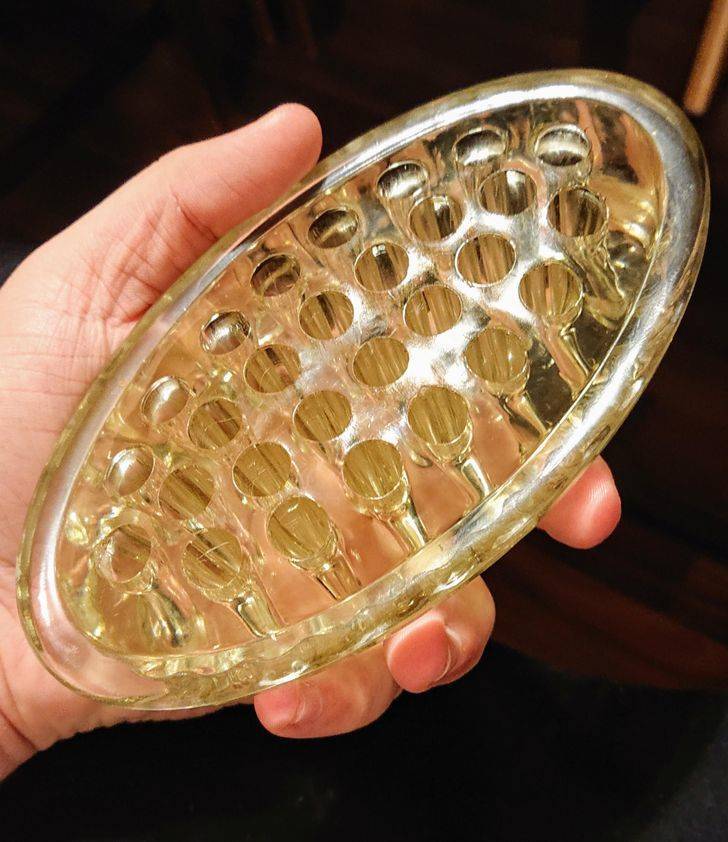 “Found in an old cabinet, made entirely of glass with narrowing holes all the way through”

A: “It’s a flower frog used to hold flower arrangements in a vase. It’s been made obsolete by foam and gel.”