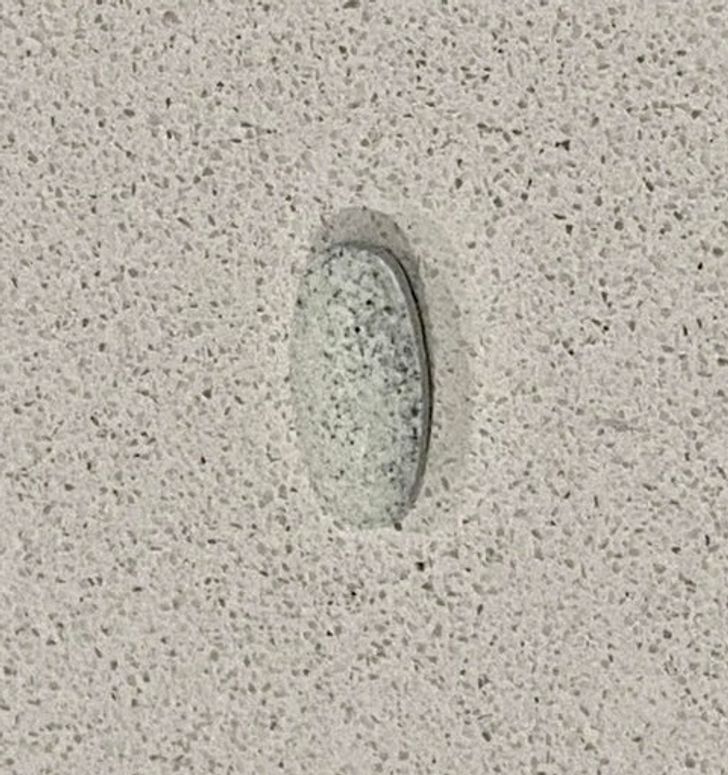 This vitamin tablet almost disappeared on this kitchen counter top.