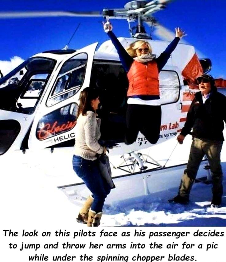 look on this pilot face - m Lak Senstow Helic Ter The look on this pilots face as his passenger decides to jump and throw her arms into the air for a pic while under the spinning chopper blades.