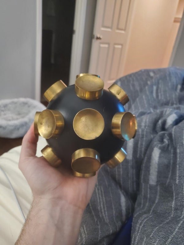 “Brass Bomb” or that's what the guy at the estate sale called it. Its heavy, metal body, and has 18 concave brass nobly things. No markings of any kind. Seems to be solid. Ideas?

A: It is just an object de décor.