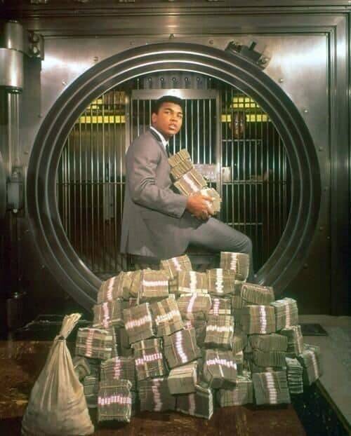 “Muhammad Ali poses with his winnings during a photoshoot in 1964.”