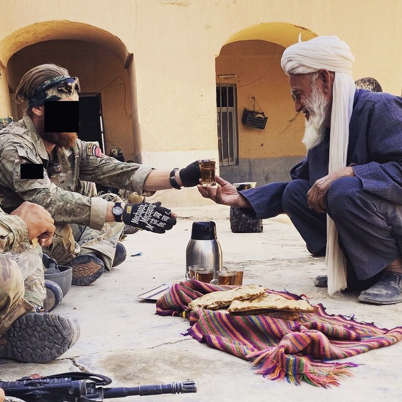 U.S. Army Green Beret accepts tea from an Afghan tribal elder