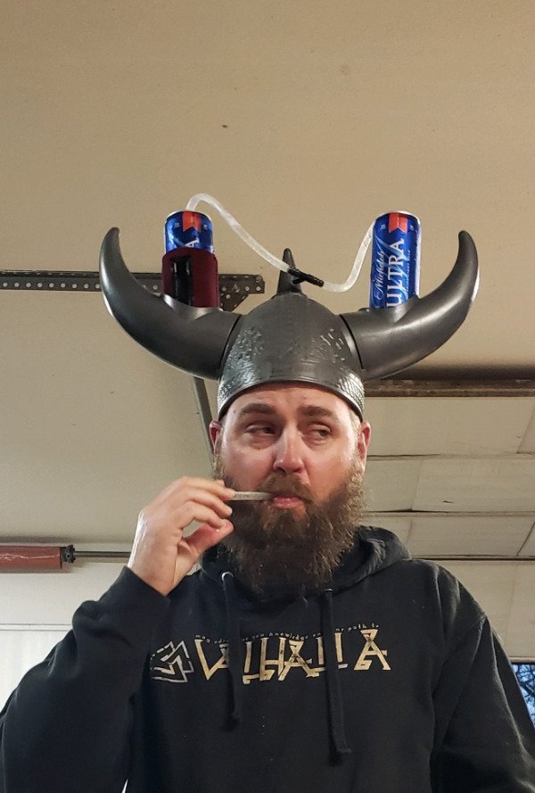 funny pictures - guy drinking two beers at the same time from a viking helmet