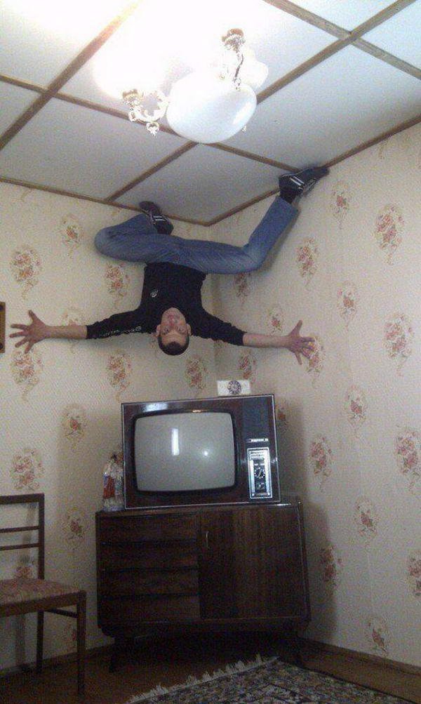 funny pictures and memes - guy crawling on the ceiling above the tv like spider-man