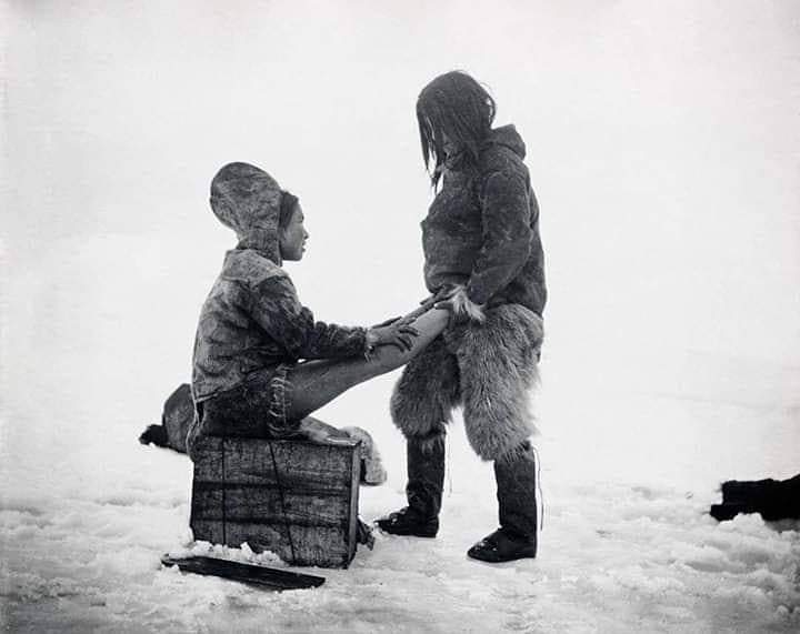 1890s inuit man warms up his wife's feet - f