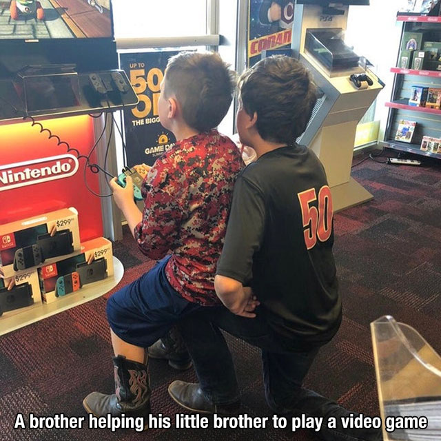 car - Dan Up To 50 Si The Bigg Game Nintendo $299 60 $299 $299 A brother helping his little brother to play a video game