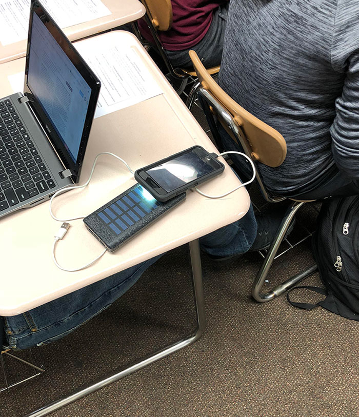 Student Uses Light On Phone To Charge Portable Solar Battery So That He Can Charge His Phone