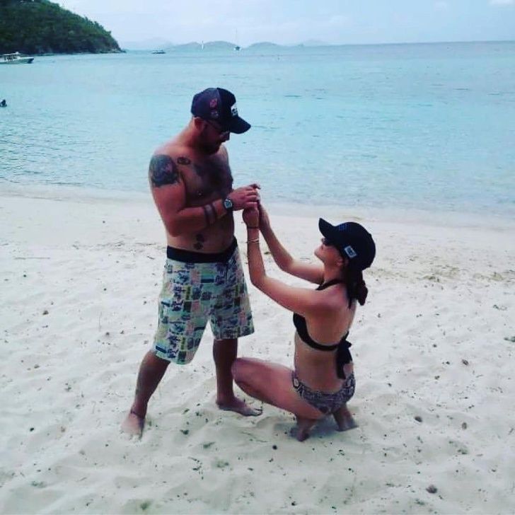 funny relationship pics - woman proposing to man on the beach