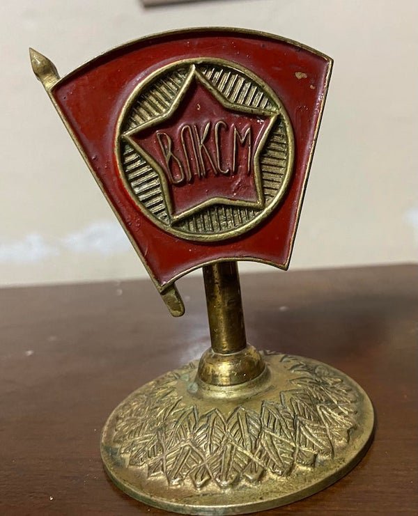 Some weird Russian thing I found in my garage.

A: This is a Komsomol emblem. The front reads “ВЛКСМ” which stood for Всесоюзный ленинский коммунистический союз молодёжи (All-Union Leninist Young Communist League)