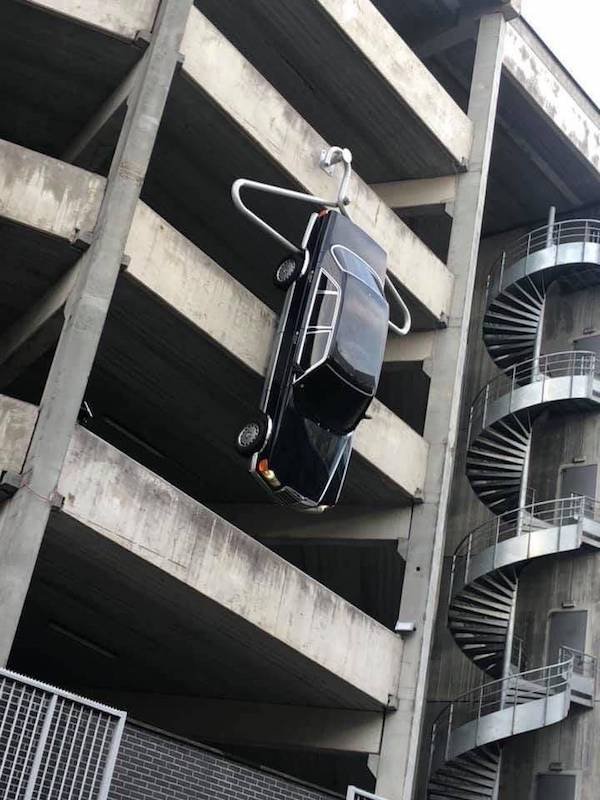 funny pics - car hung off building by clothes hanger