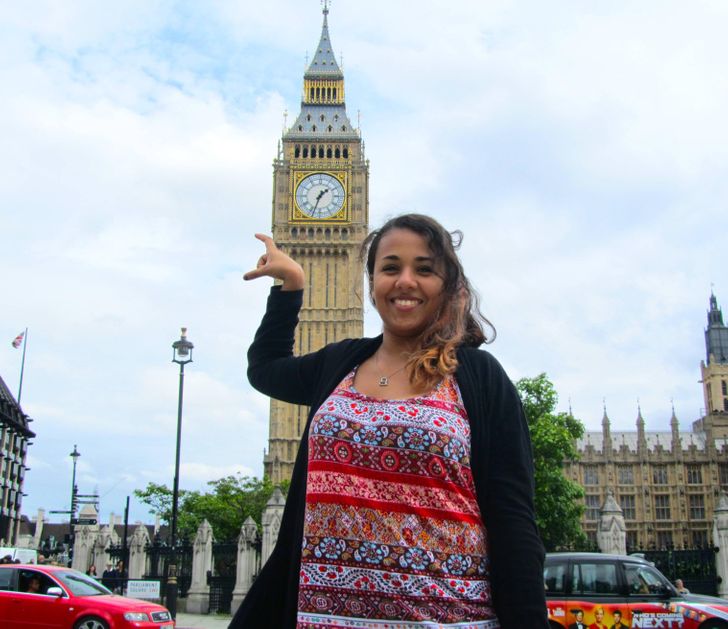 funny sibling pics - woman failing to hold big ben clock in photo