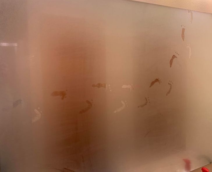 funny sibling pics - steamed shower glass with creepy footprints on it