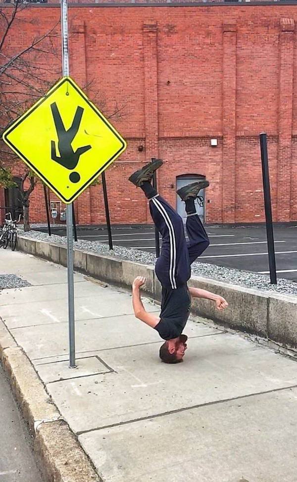funny pics - road sign upside down guy standing on his head funny