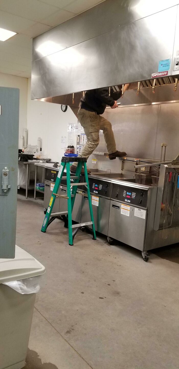 funny construction fails - guy balancing on stove in kitchen