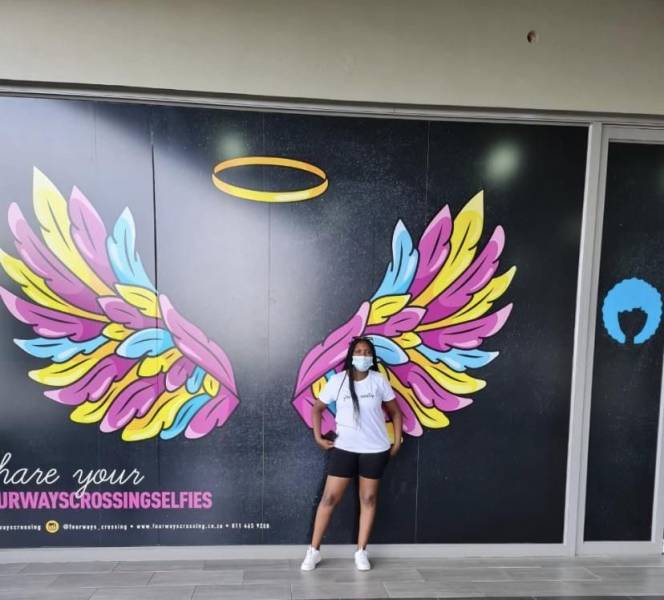 funny pics - woman failing to pose in front of angel wings mural