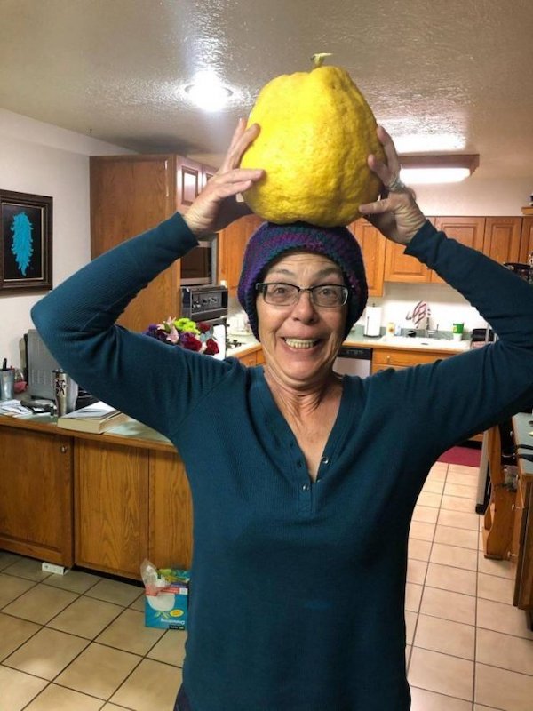 funny pics - woman holding giant lemon on her head