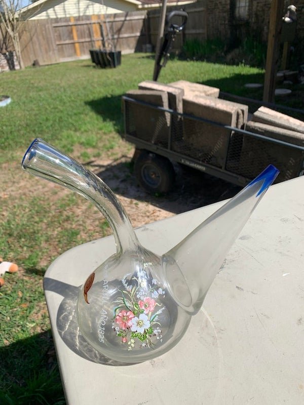 Glass vase thing found in a thrift store in Navarre, FL.

A: It’s a kind of wine bottle used in Spain, specifically Catalonia. You drink from it by pouring a stream through the air and directly into your mouth. It’s called a Porron.