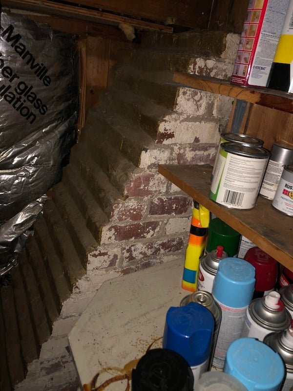 What is this brick pyramid/steps structure in basement of historic house- there is no opening that I’ve found

A: Probably a simple buttress