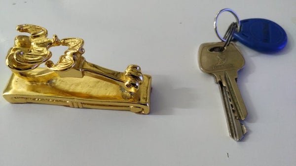 What is this golden metal item, heavy with a flat bottom?

A: A fancy paper weight