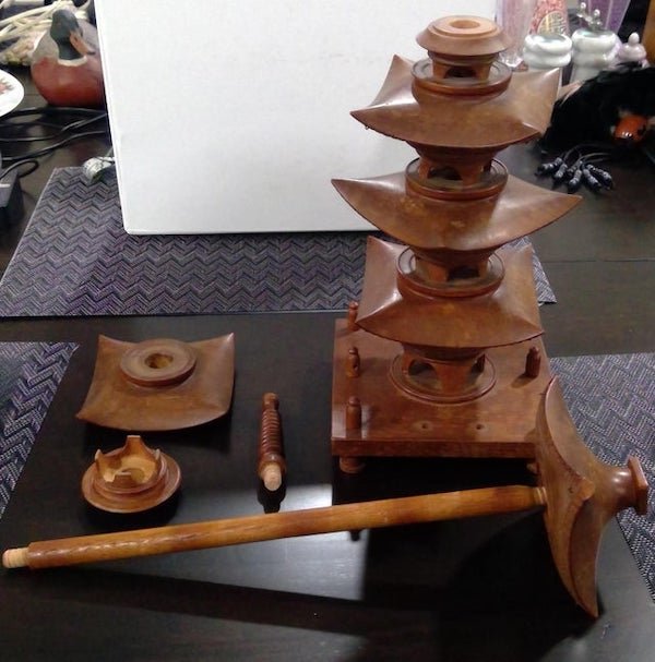 Wood thing that spins, all parts come off. Has weird loops in corners like if string can be attached

A: It’s a Japanese model of a pagoda. The loops in the corners are to attach bells.