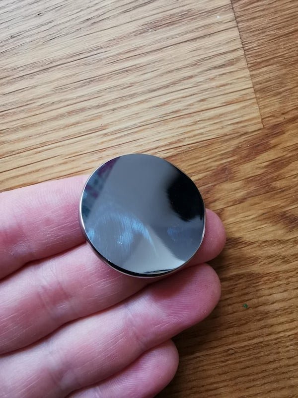 3cm diameter metal disk with a screw back. Looks shiny and new, no idea what it could be.

A: It was from our upstairs radiator! Apparently our toddler must have put it in the washing  it goes on the end of the knobs to turn it on.