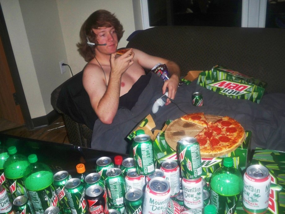 funny pics and memes - shirtless guy playing video games eating pizza surrounded by mountain dew