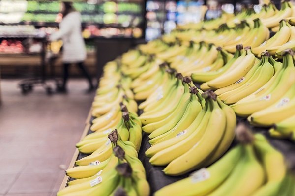 fruit aisle in supermarket filled with bananas