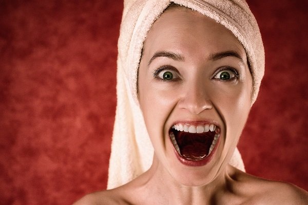 woman smiling wearing bath towel on head