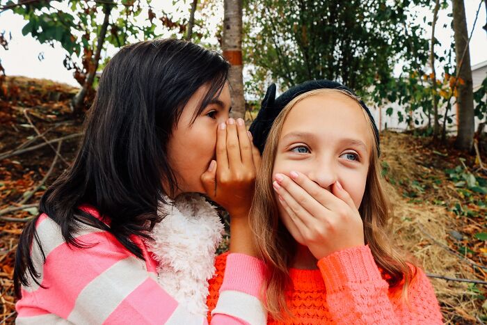social etiquette rules - girl whispering to another girl
