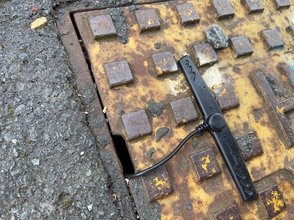 UK here. Why is there a ‘Super Antenna’ glued onto a drain cover? Drain is stamped with ‘FH’ and sprayed blue just off shot, this antenna is glued down tight.

A: It’ll be for a monitoring system of some sort. Could be to track how much waste water goes through the drain, could be for monitoring gas buildup, there might even be a gas or water meter down there and it reports the metering data so they don’t have to send out readers into a possibly hazardous environment so often.